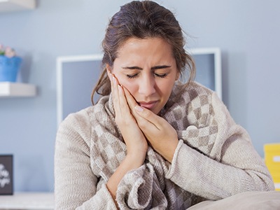 Woman holding cheek in pain