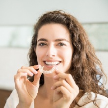 woman holding clear aligner