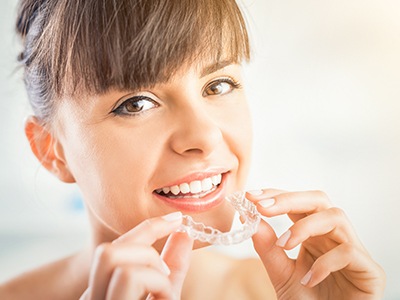 Woman placing Invisalign tray