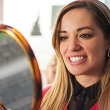 Woman looking at smile in mirror