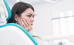 Woman holding cheek in pain